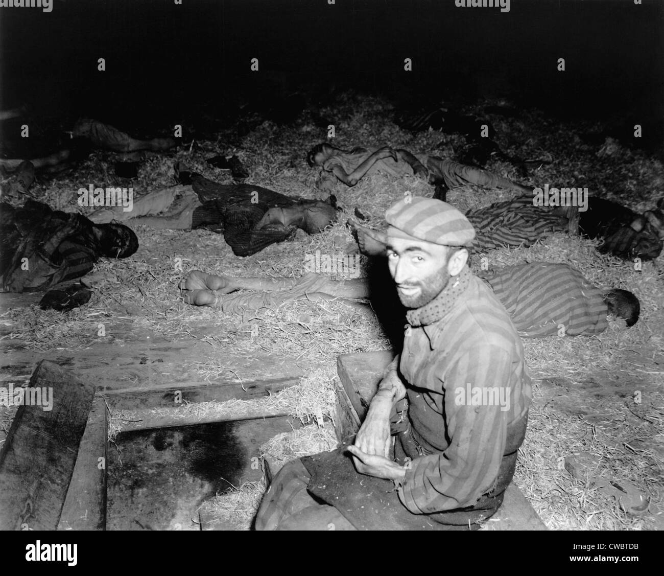 Abgemagert Franzose sitzen unter den Toten in Gefangenenlager, Nordhausen, Deutschland nach der Befreiung durch die 1. US-Armee am 11. April, Stockfoto