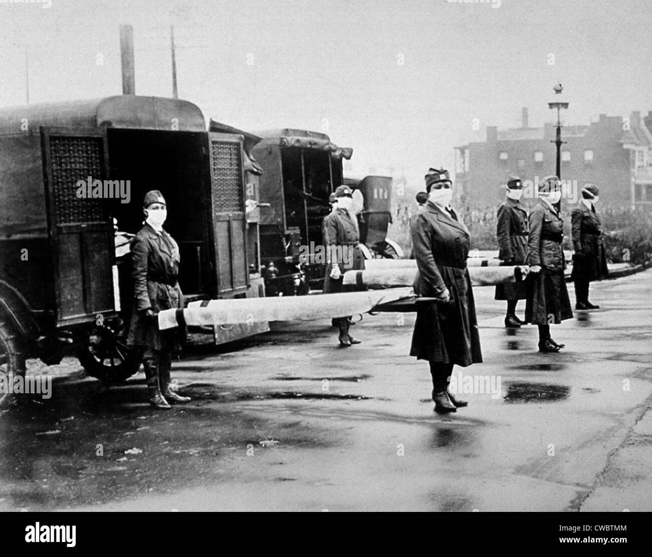 Spanische Grippe-Epidemie 1918 / 19.  Maskierte amerikanische nationale Rote Kreuz Krankenschwestern mit Bahren bei Krankenwagen Bohren für die Behandlung von Stockfoto