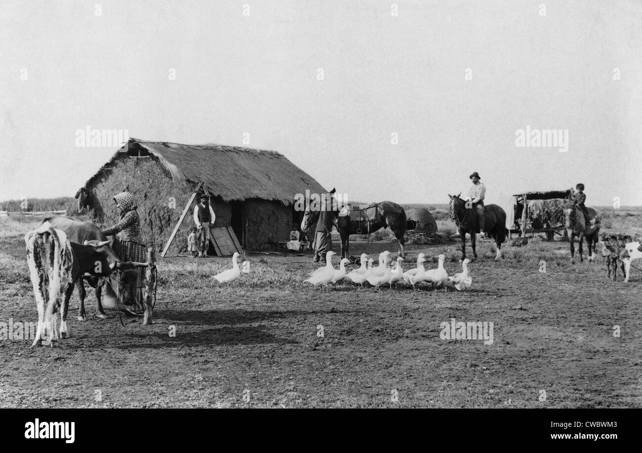 Einwanderer die Heimat der primitiven Bau im ländlichen Argentinien, mit Männern, Frauen und Kinder vor Haus, mit Pferden, Stockfoto