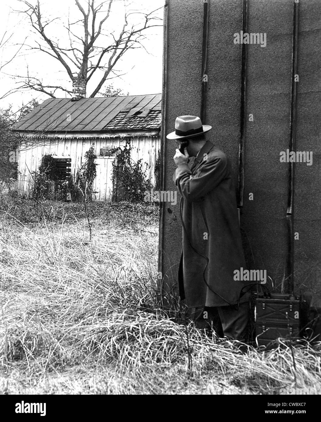 FBI-Agenten mit einem riesigen tragbare Telefon während einer Entführung Absteckung. Ca. 1940er Jahre. Stockfoto