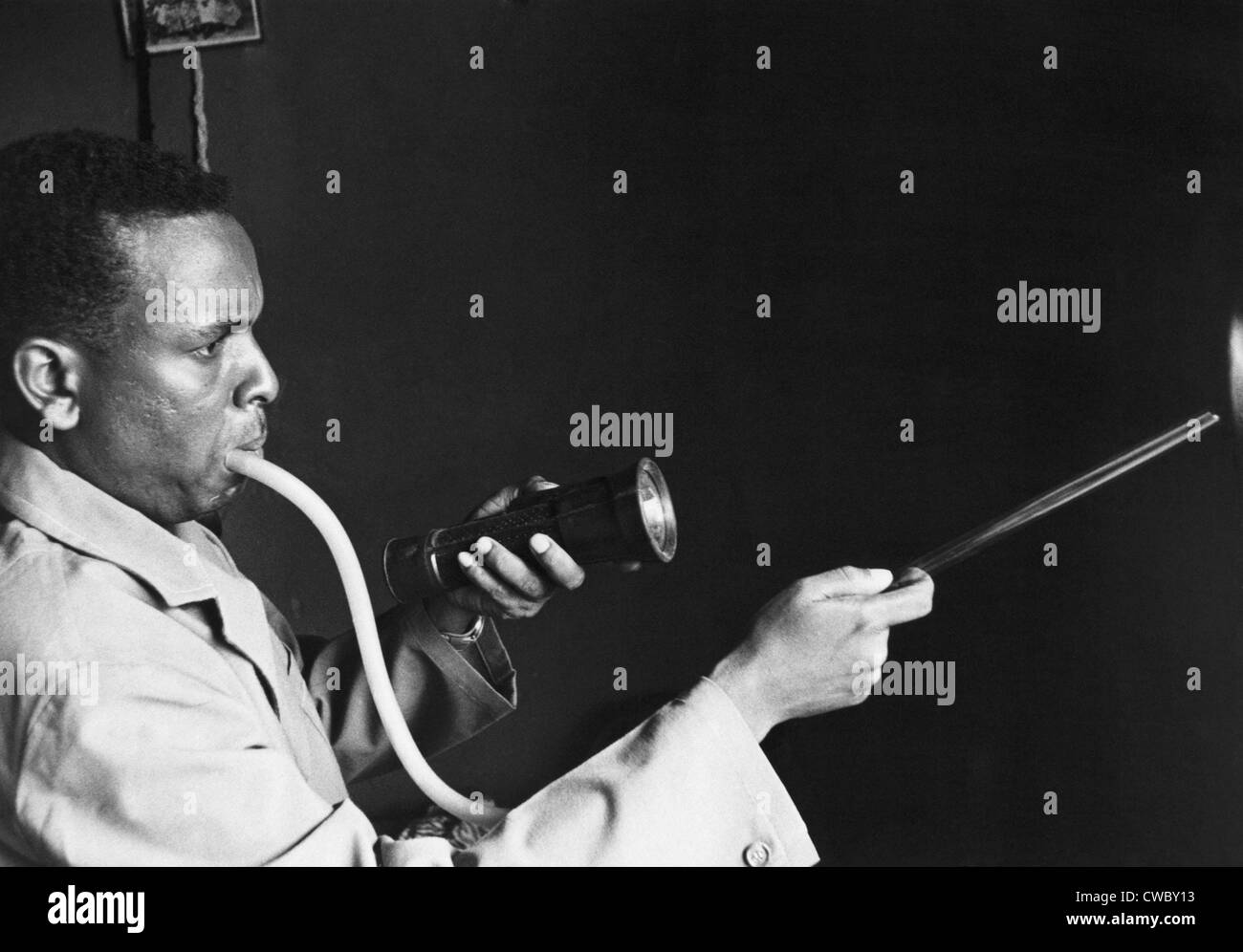 Togoische Mann mit einer Mund-Inhalator, um Moskitos zu erfassen, die Ausbreitung von Malaria zu verhindern. 1964. Stockfoto