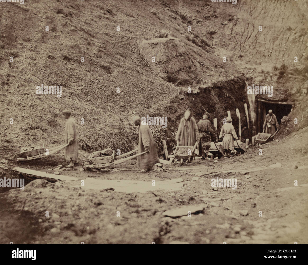 Turkestanisch Arbeitnehmer schleppen Kohle aus einem unterirdischen mine Gewinnung von Kohle dicht unter der Oberfläche mit vorindustriellen Methoden Stockfoto
