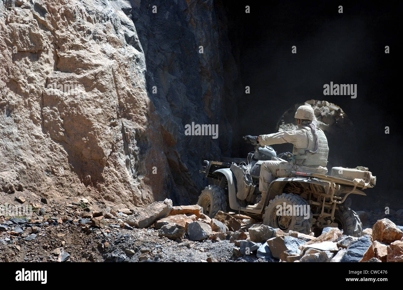 Ein Soldat der US-Armee reitet ein All-Terrain-Fahrzeug in eine Höhle zu suchen Munition am Stadtrand von Kabul Afghanistan. Stockfoto