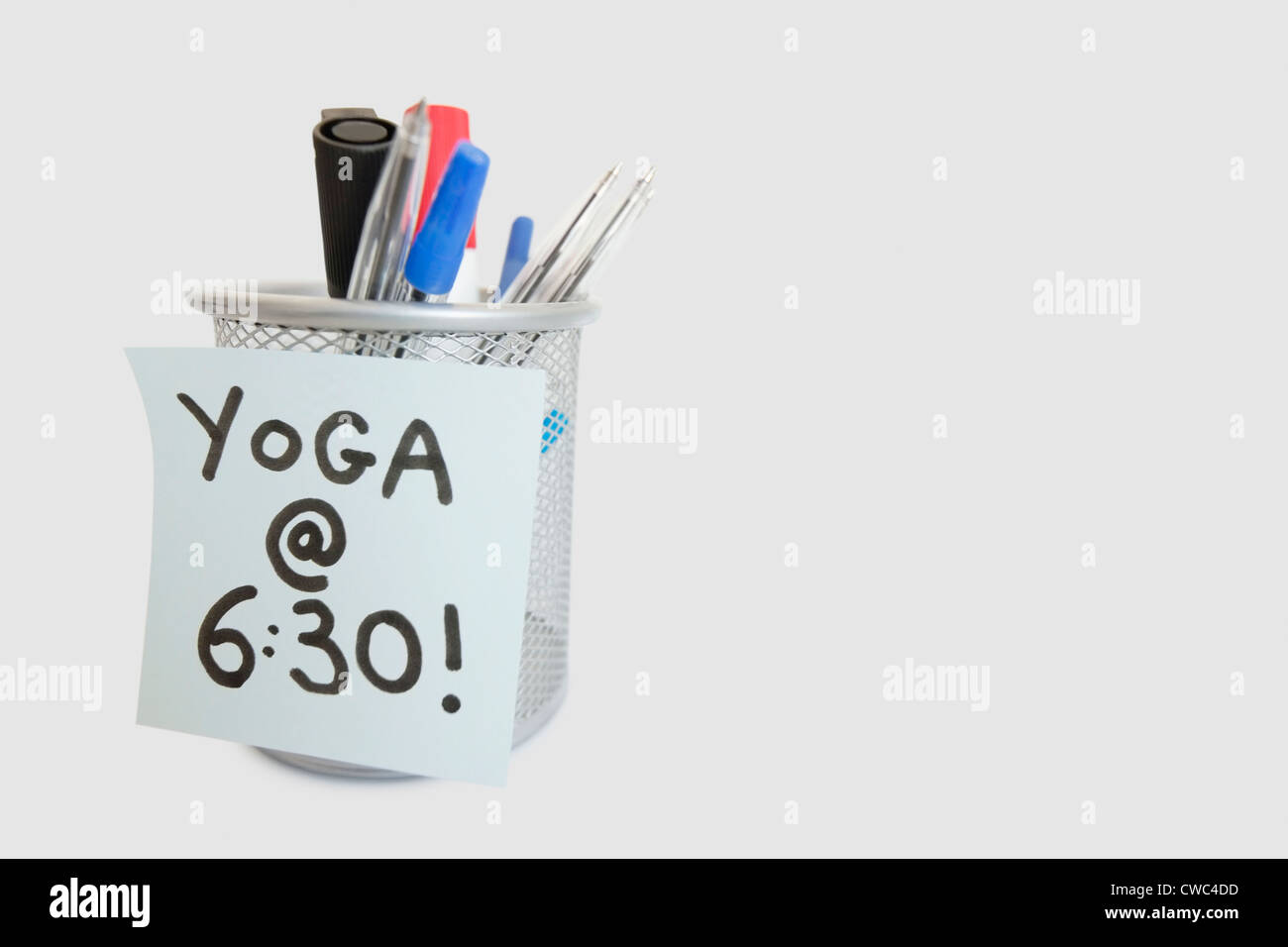 Nahaufnahme der Haftnotiz mit Yoga Nachricht auf Stifthalter auf weißem Hintergrund Stockfoto