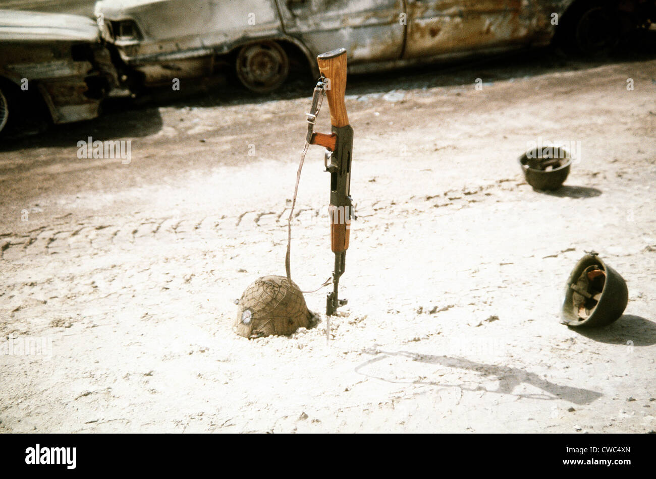 Ausrangierte irakischen Helme verstreut eine Kalaschnikow in der Nähe von Fahrzeugen durch Koalitionstruppen während zerstört Stockfoto