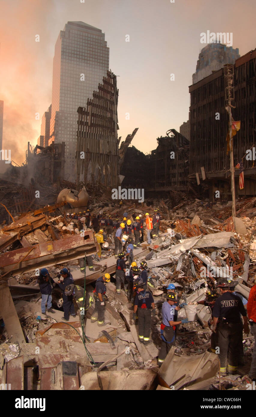 Feuerwehrleute und Rettungskräfte arbeiten auf den Haufen Schutt aus dem eingestürzten World Trade Center. Auf der Rückseite steht fest Stockfoto