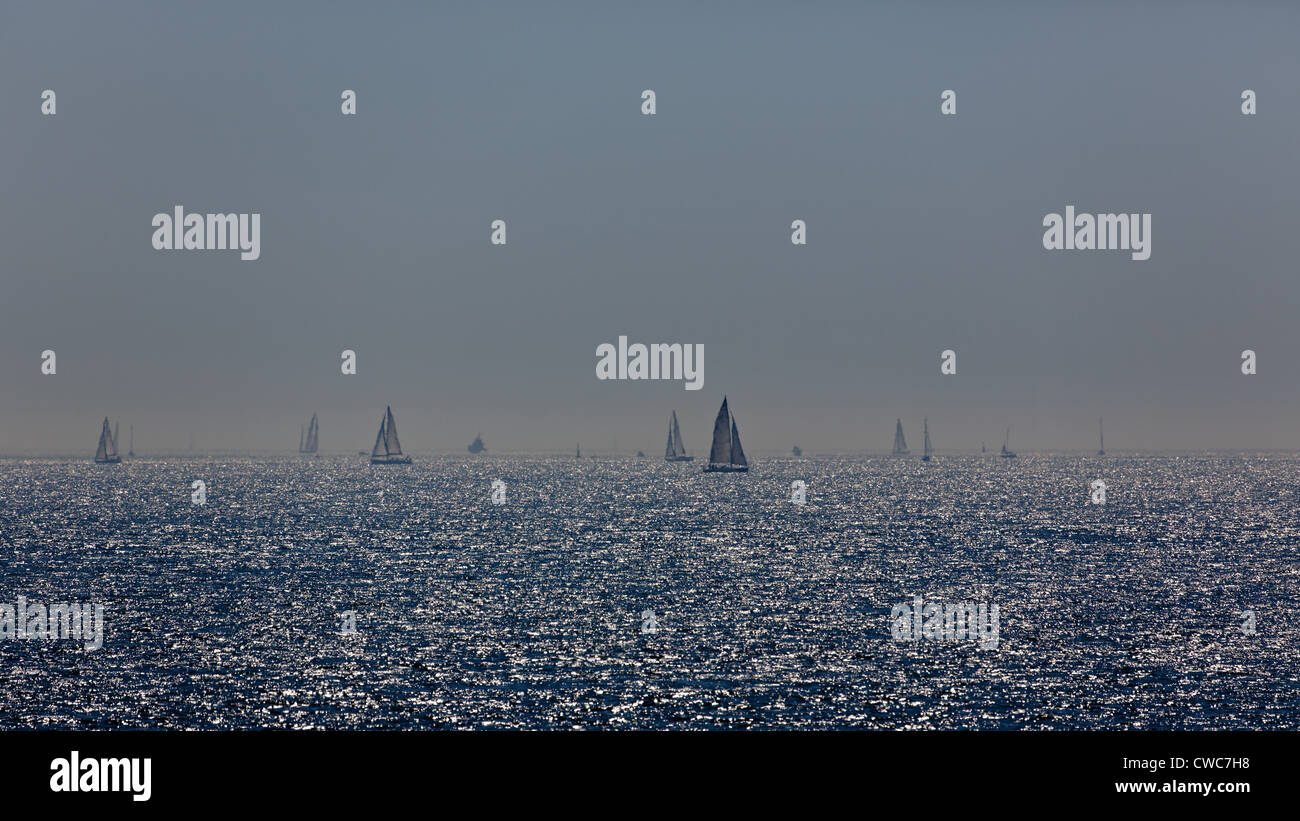 Segelboote, gesehen durch die sommerlichen Dunst auf dem Solent, Hampshire, UK Stockfoto