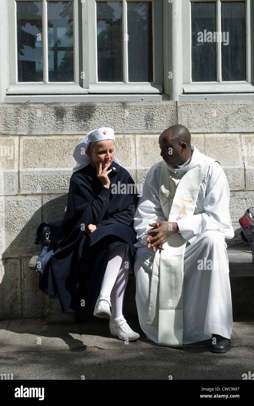 Eine italienische Schwester im Gespräch mit einem Priester in Lourdes, Frankreich Stockfoto