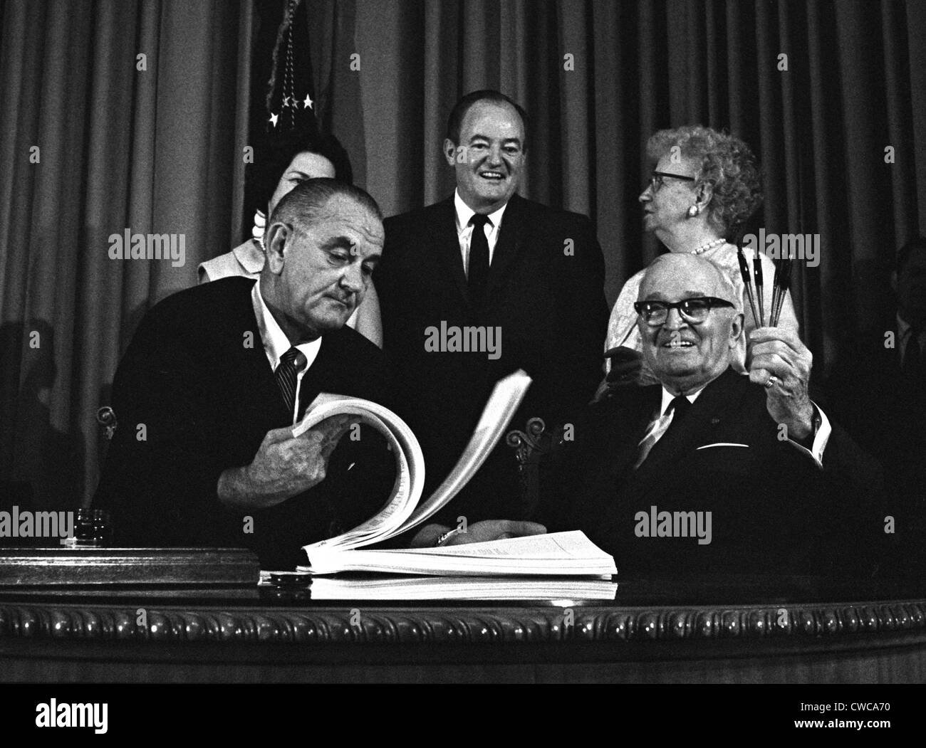 LBJ es Great Society Programme. Präsident Lyndon Johnson Unterzeichnung der Medicare-Rechnung mit dem ehemaligen Präsidenten Harry Truman, der erste Stockfoto