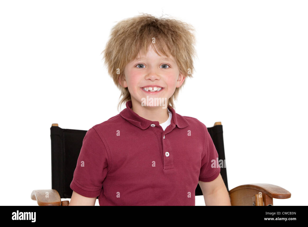 Portrait eines glücklichen Schule Jungen sitzen auf Regiestuhl auf weißem Hintergrund Stockfoto
