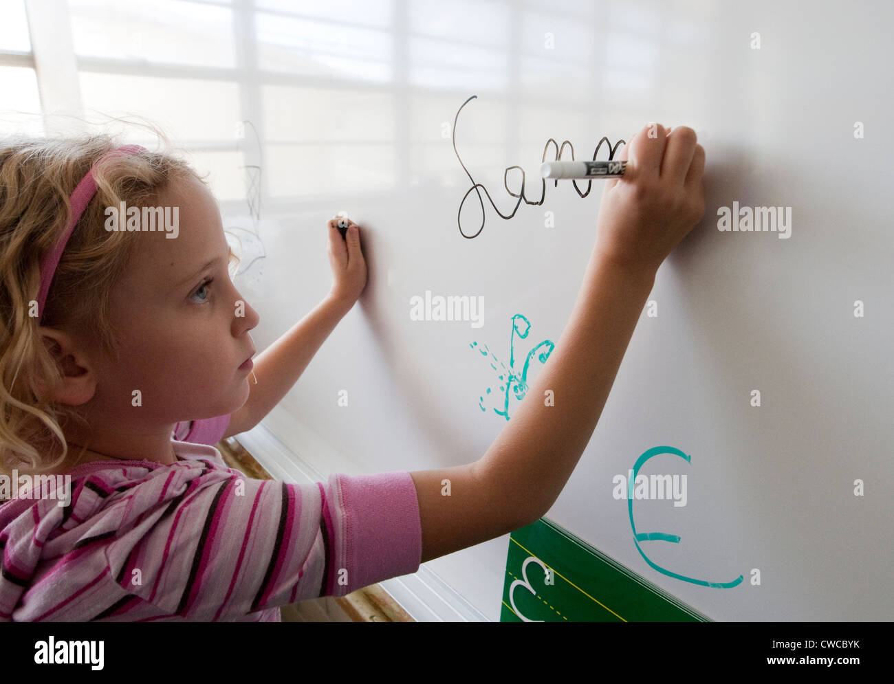 7 Jahre alten Mädchen Praktiken ihr Name in Schreibschrift auf Tafel  schreiben Stockfotografie - Alamy