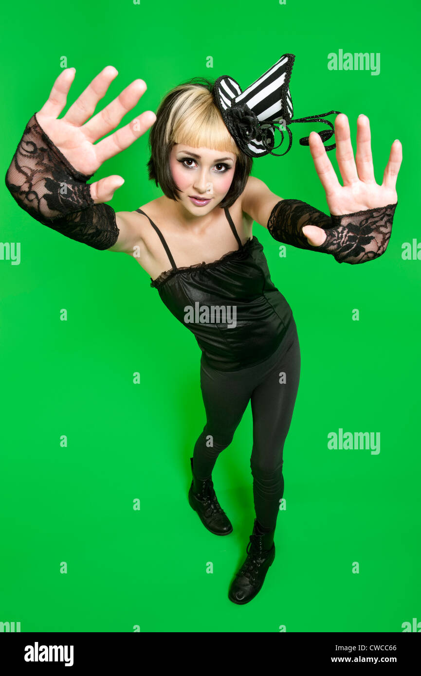 Portrait von junge Frau posiert mit fingerlose Handschuhe und Kopfschmuck auf grünem Hintergrund Stockfoto