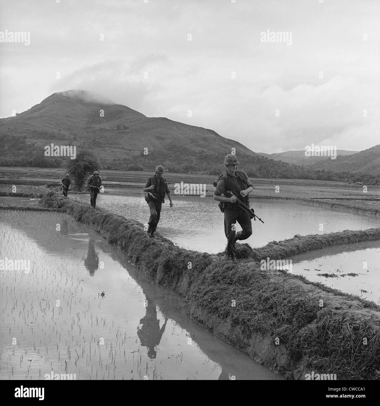 Vietnam-Krieg. US Marines bewegen sich entlang Reis Paddy Deiche bei der Verfolgung der Viet Cong. Dec. 10, 1965. Stockfoto