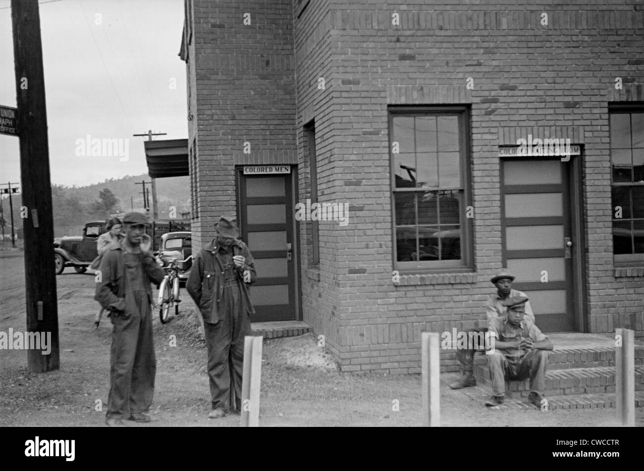 Farbige Wartezimmer Zeichen. Vier afroamerikanische Männer stehen außerhalb der Manchester, Georgia Railroad Station. Mai 1938. Stockfoto