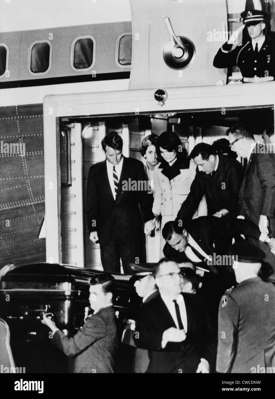 John Kennedys Sarg. Robert Kennedy hält Jacqueline Kennedys Hand, wie sie den Körper des ermordeten Präsidenten zu sehen Stockfoto