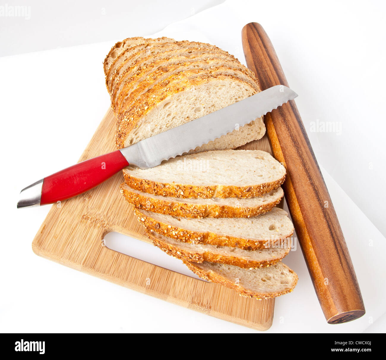Schnittbrot auf ein Schneidebrett mit Messer und Nudelholz. Stockfoto