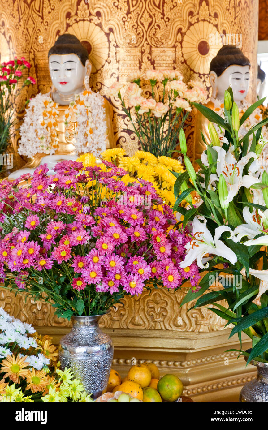 Myanmar, Burma. Blüten und Früchte als Opfergaben in einem buddhistischen Schrein auf dem Zayar Thein Gyi Kloster in der Nähe von Mandalay. Stockfoto