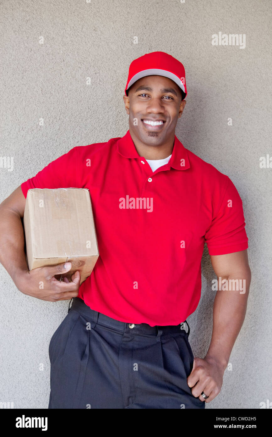 Porträt eines glücklichen jungen Mannes Lieferbox Wand halten Stockfoto