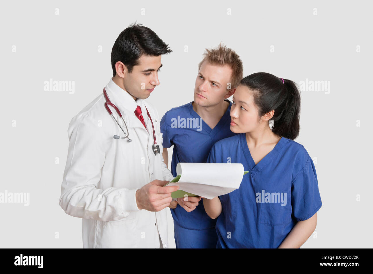 Multi ethnischen Gesundheitsexperten diskutieren Krankenbericht über grauer Hintergrund Stockfoto
