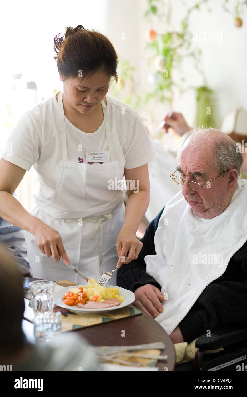 Mainz, eine Krankenschwester hilft einen älteren Mann beim Essen Stockfoto