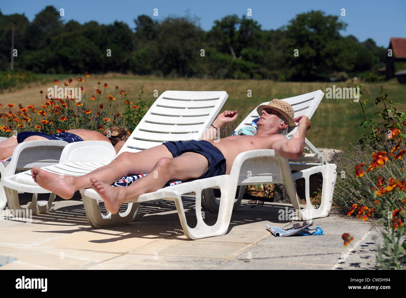 Mann auf einer Liege Schwimmbad im Land Urlaub Ferienhaus in die Menge Region von Frankreich Südwesteuropa Sonnenbaden Stockfoto
