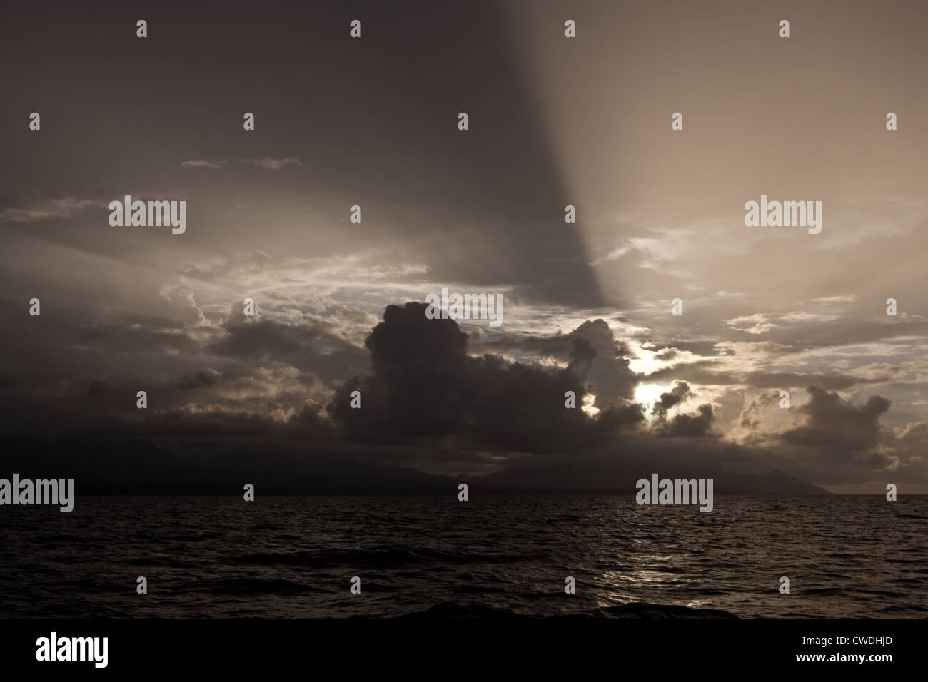 Späten Nachmittag Sonne strahlt durch niedrige Wolken, wie sie in der Nähe der Insel Guadalcanal auf den Salomonen zu sammeln. Stockfoto