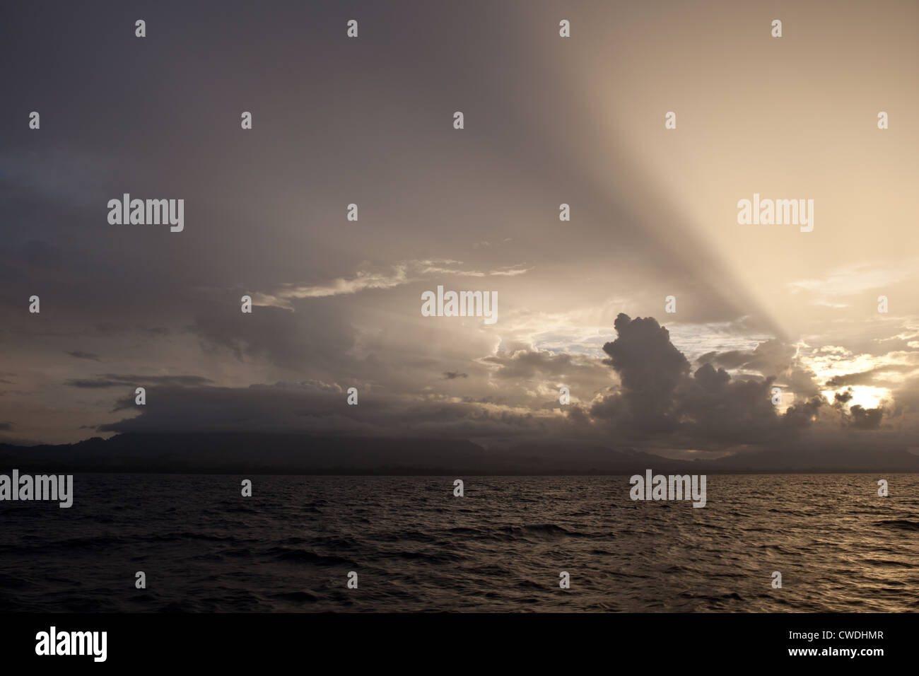 Späten Nachmittag Sonne strahlt durch niedrige Wolken, wie sie in der Nähe der Insel Guadalcanal auf den Salomonen zu sammeln. Stockfoto