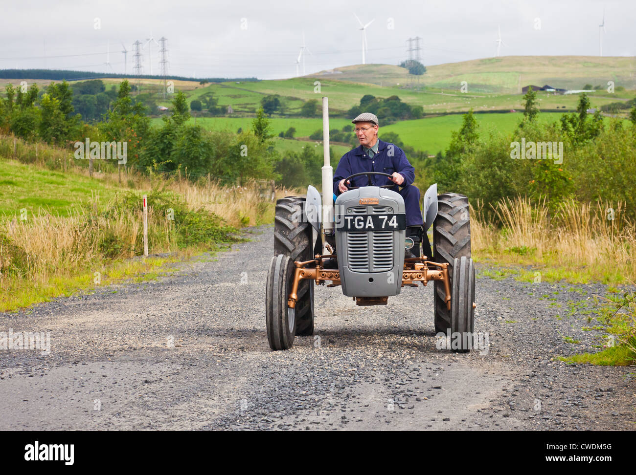 Enthusiasten, die einen grauen Vintage Ferguson FE35 Traktor zu fahren, während ein Ayrshire Oldtimer Traktor und Maschine Club Straße laufen. Stockfoto