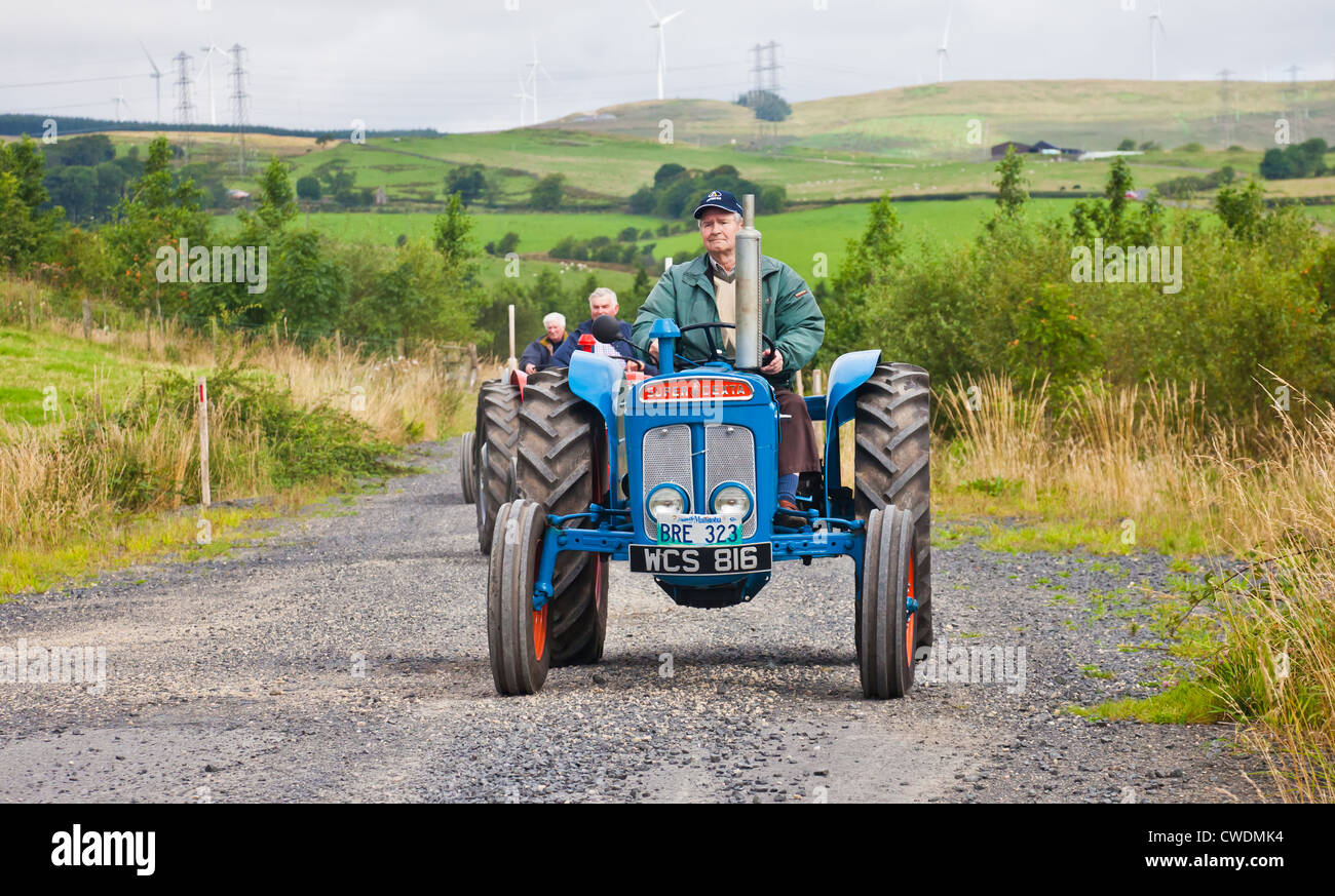 Enthusiast einen blauen Vintage Fordson Super Dexta Traktor zu fahren, während ein Ayrshire Oldtimer Traktor und Maschine Club Straße laufen. Stockfoto