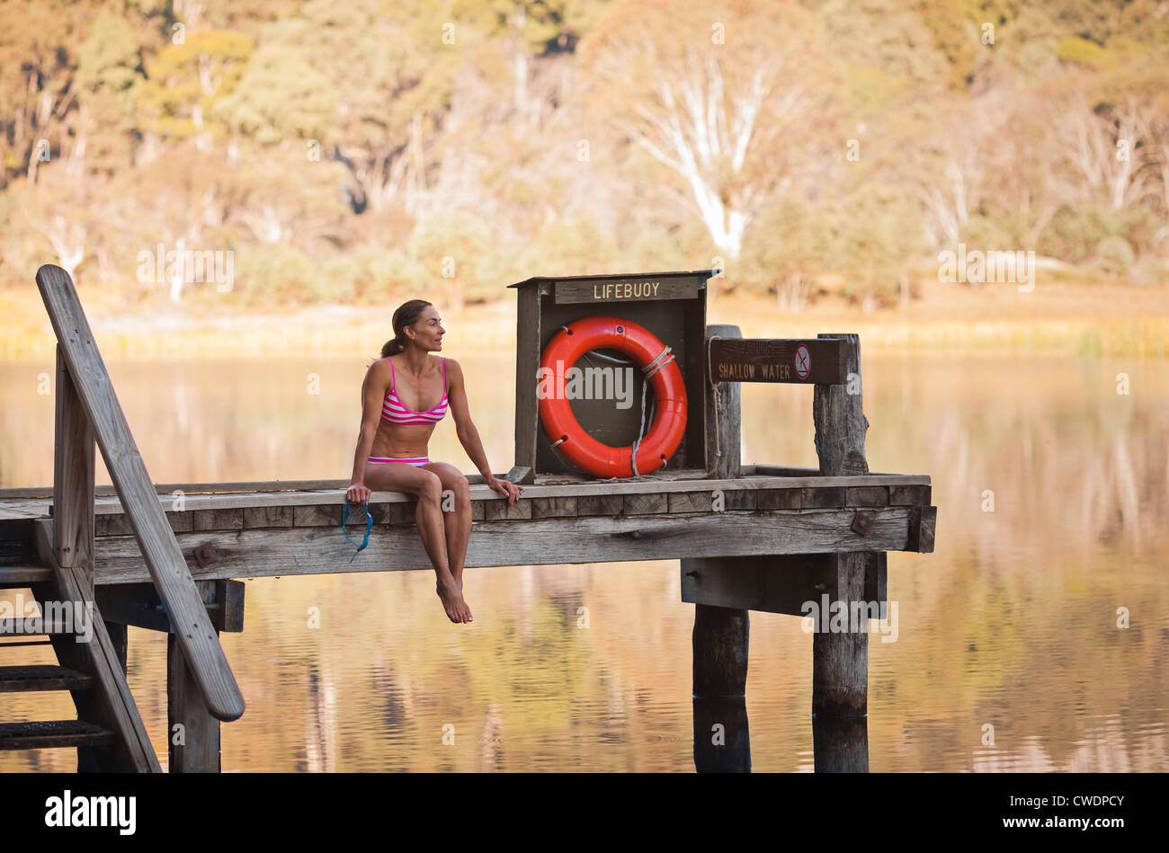 Eine Frau sitzt mit einer Lake, Mount Buffalo National Park, Victoria, Australien. Stockfoto