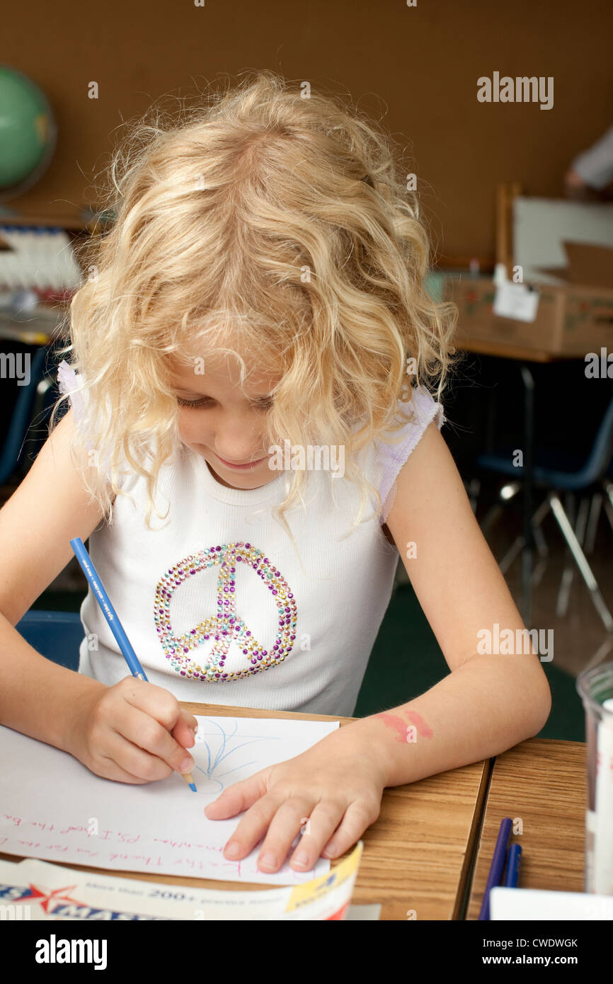 7 Jahre alten weißen Blondine verwendet farbige Bleistift auf weißem Papier am Schalter zeichnen Stockfoto