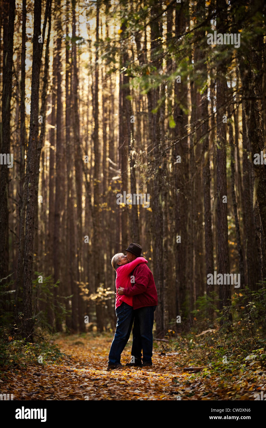 Ein glückliches Paar zu lachen und Lächeln während auf einer Wanderung durch den Wald im Herbst in Idaho im Ruhestand. Stockfoto