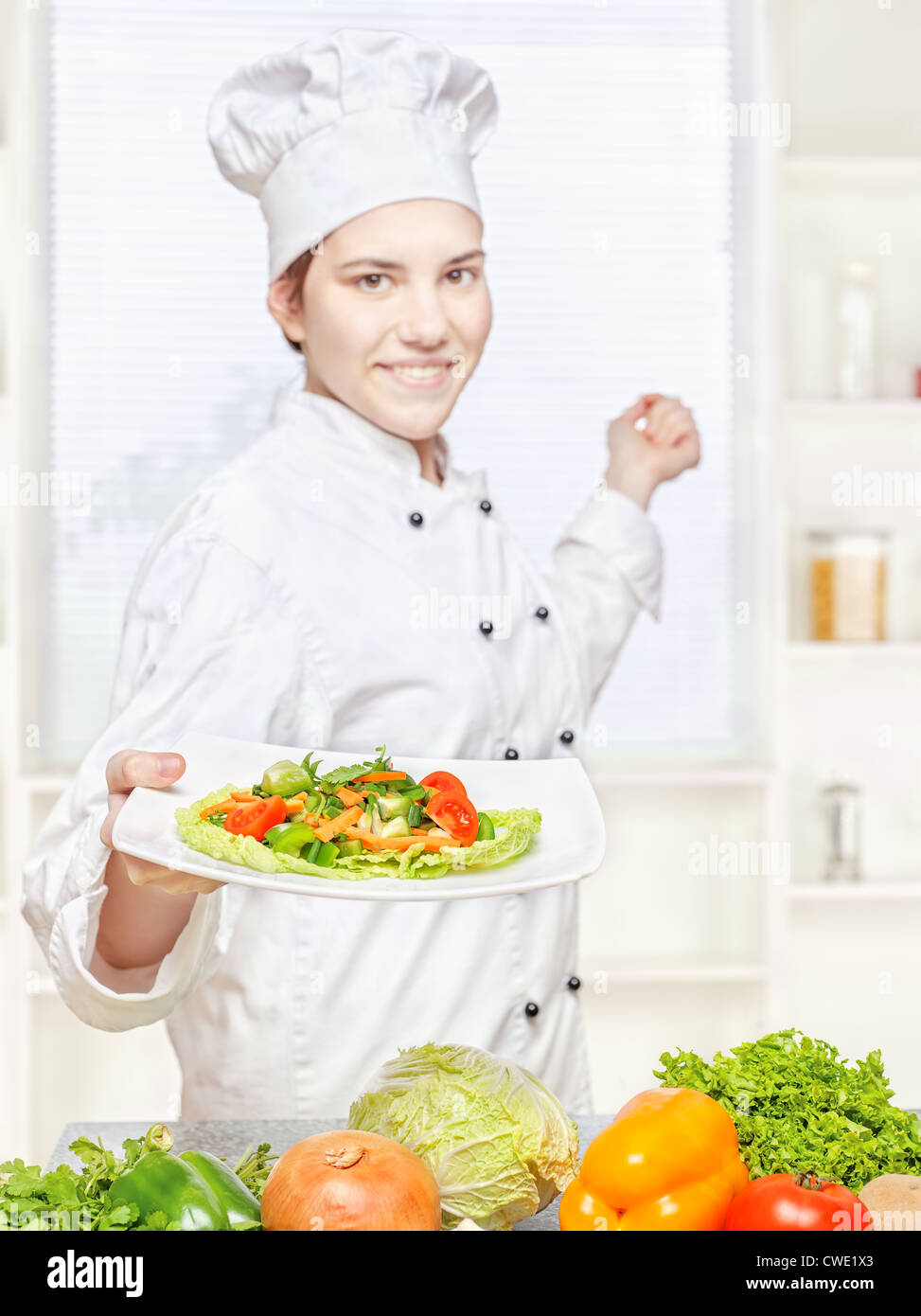 Jungkoch mit vegetarischen Mahlzeit in Küche, Fokus auf Salat Stockfoto