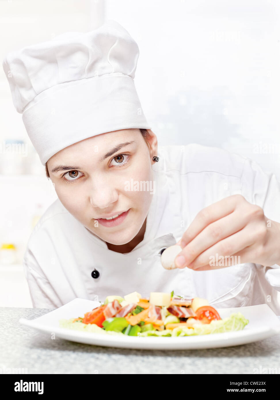 hübsche junge Küchenchef köstliche Salat dekorieren Stockfoto