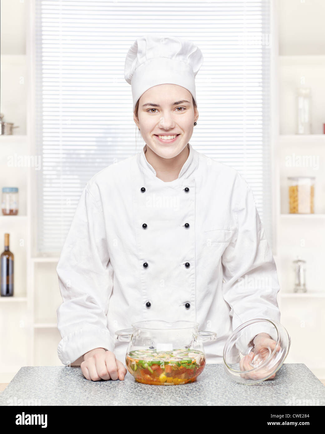 Koch in der Küche mit einer Suppe Gemüse im Glas Stockfoto