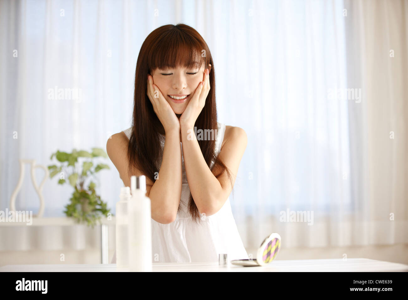 Japanerin mit Kopf lächelnd In der Hand Stockfoto