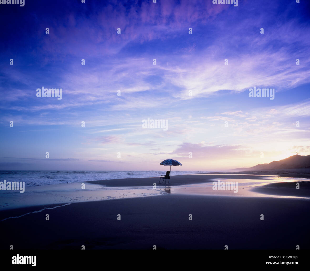 Leeren Sie Liegestuhl und Baldachin am Strand in der Abenddämmerung Stockfoto