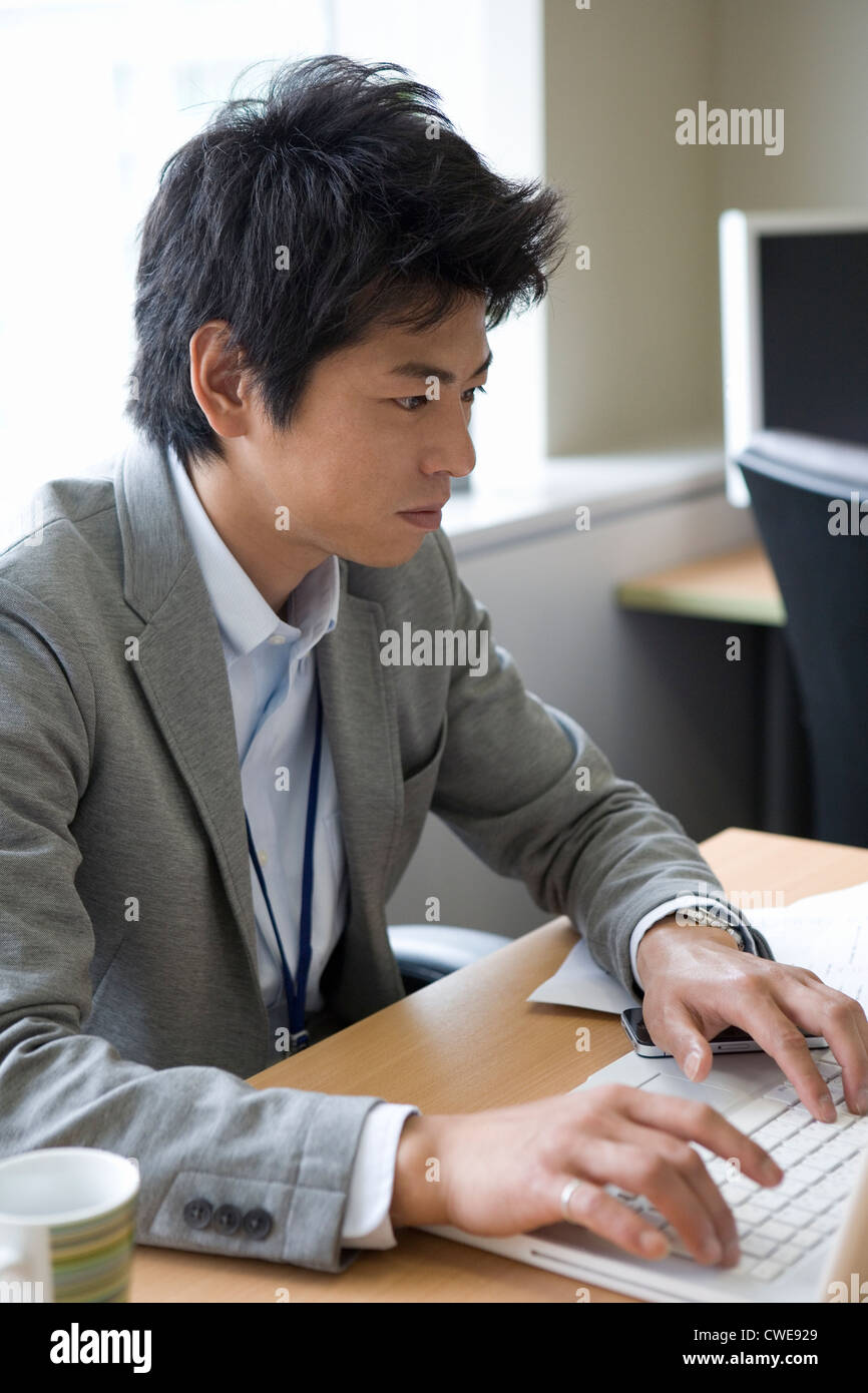 Geschäftsmann, sitzen und mit Laptop am Schreibtisch Stockfoto