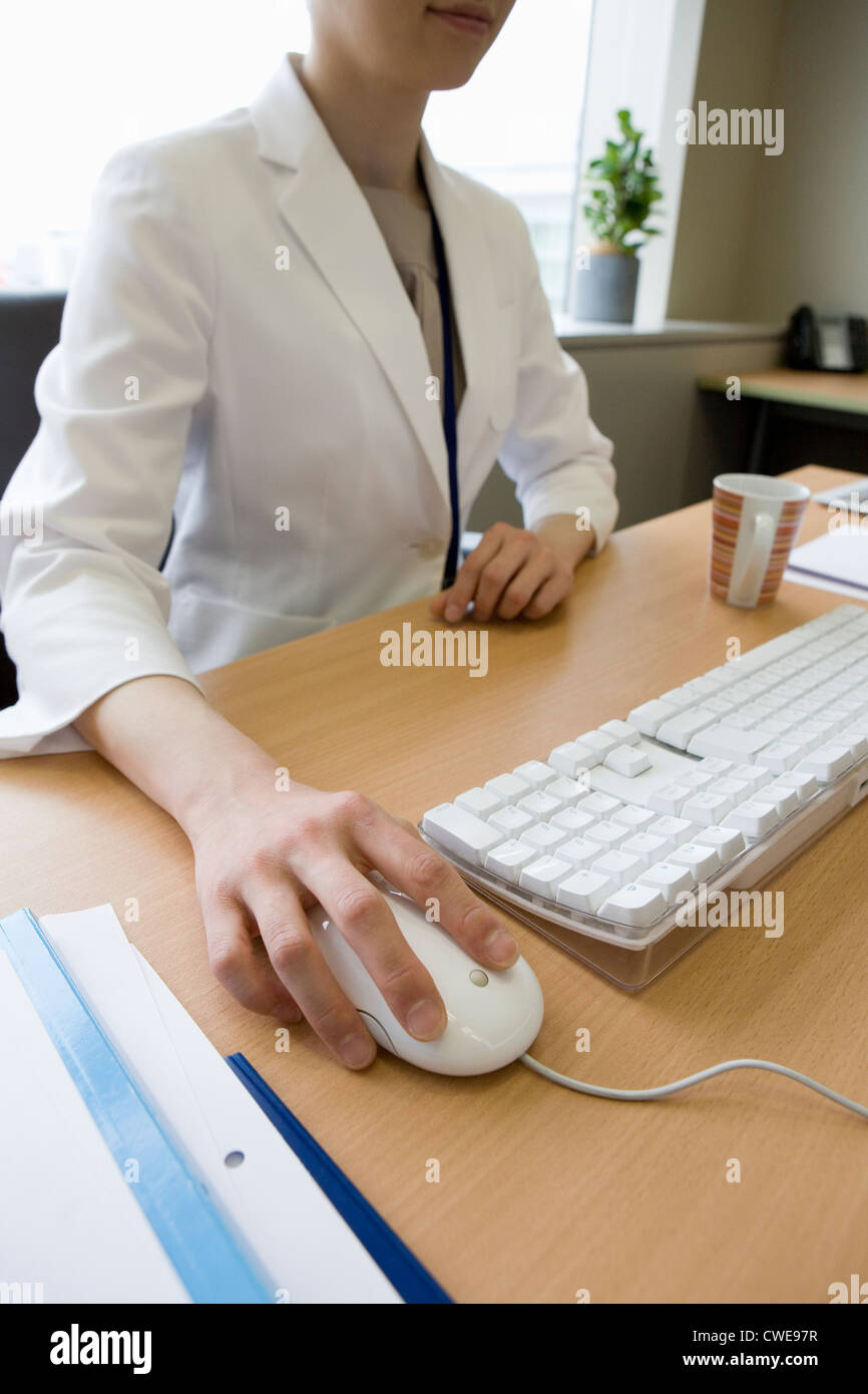 Geschäftsfrau hält Computer-Maus Stockfoto