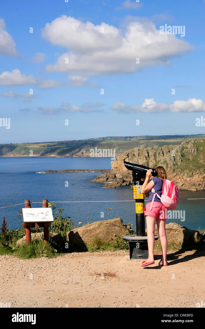 Ein junges Mädchen anzeigen die kornische Küste bei Lands End durch ein Pay-per-Teleskop Stockfoto