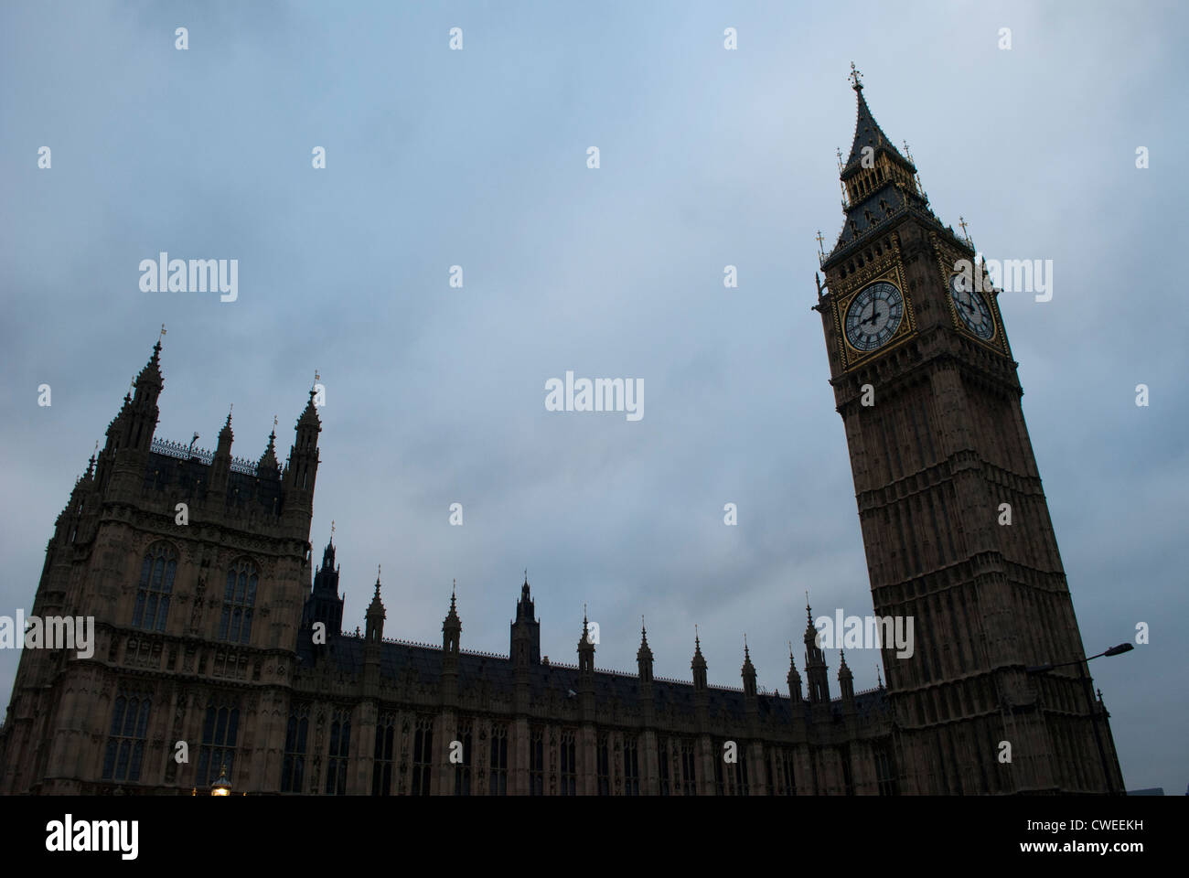 Big Ben und der Palace of Westminster leuchtet dunkel gegen ein bewölkter Himmel Stockfoto