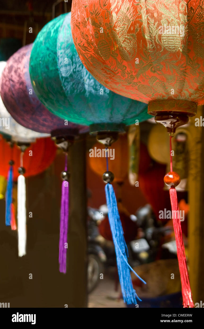 Vertikale Nahaufnahme von traditionellen Seidenlaternen hängen in der Sonne in Vietnam. Stockfoto