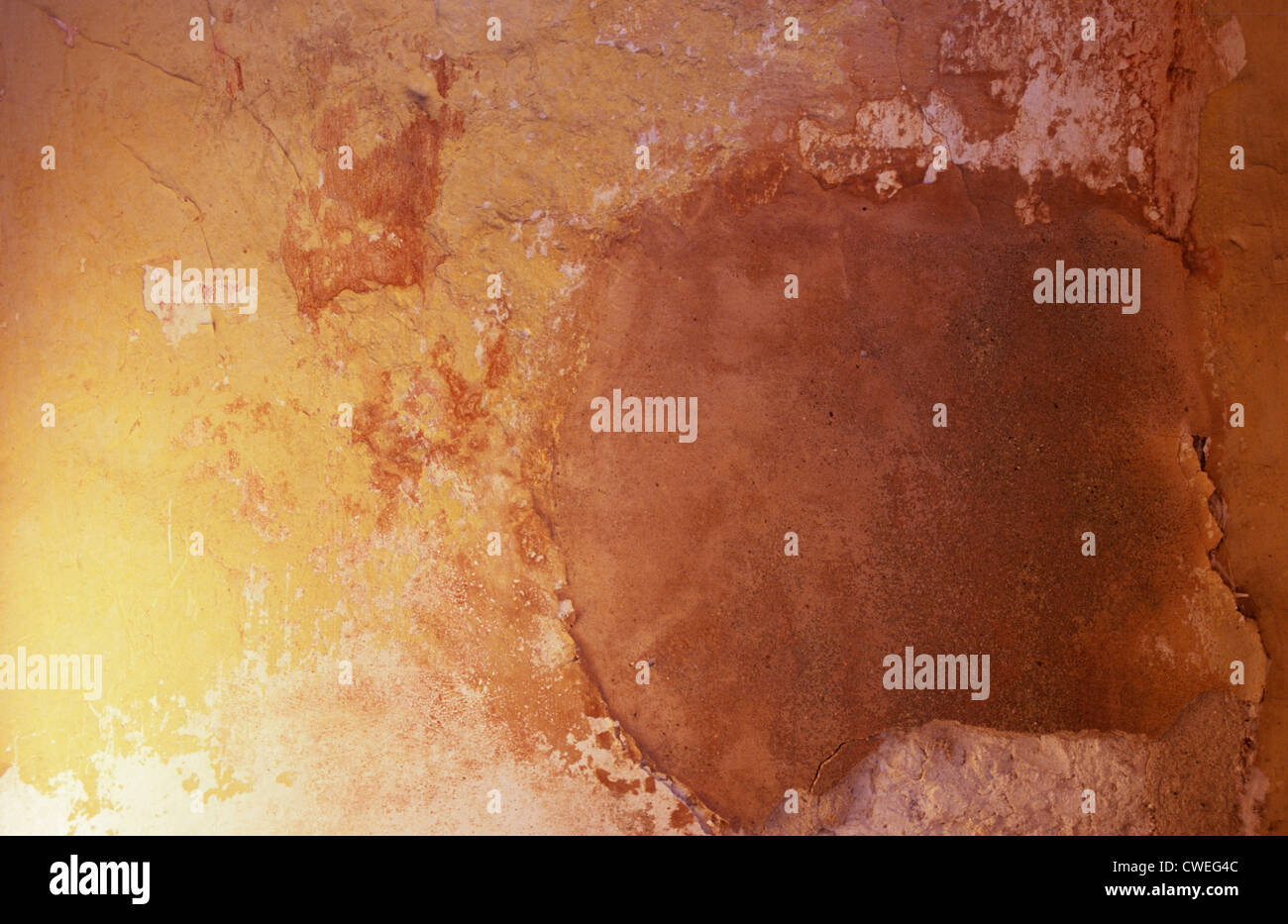 Ausschnitt aus grob verputzte Wand geflickt und Ocker in warmes Licht gemalt wurde Stockfoto