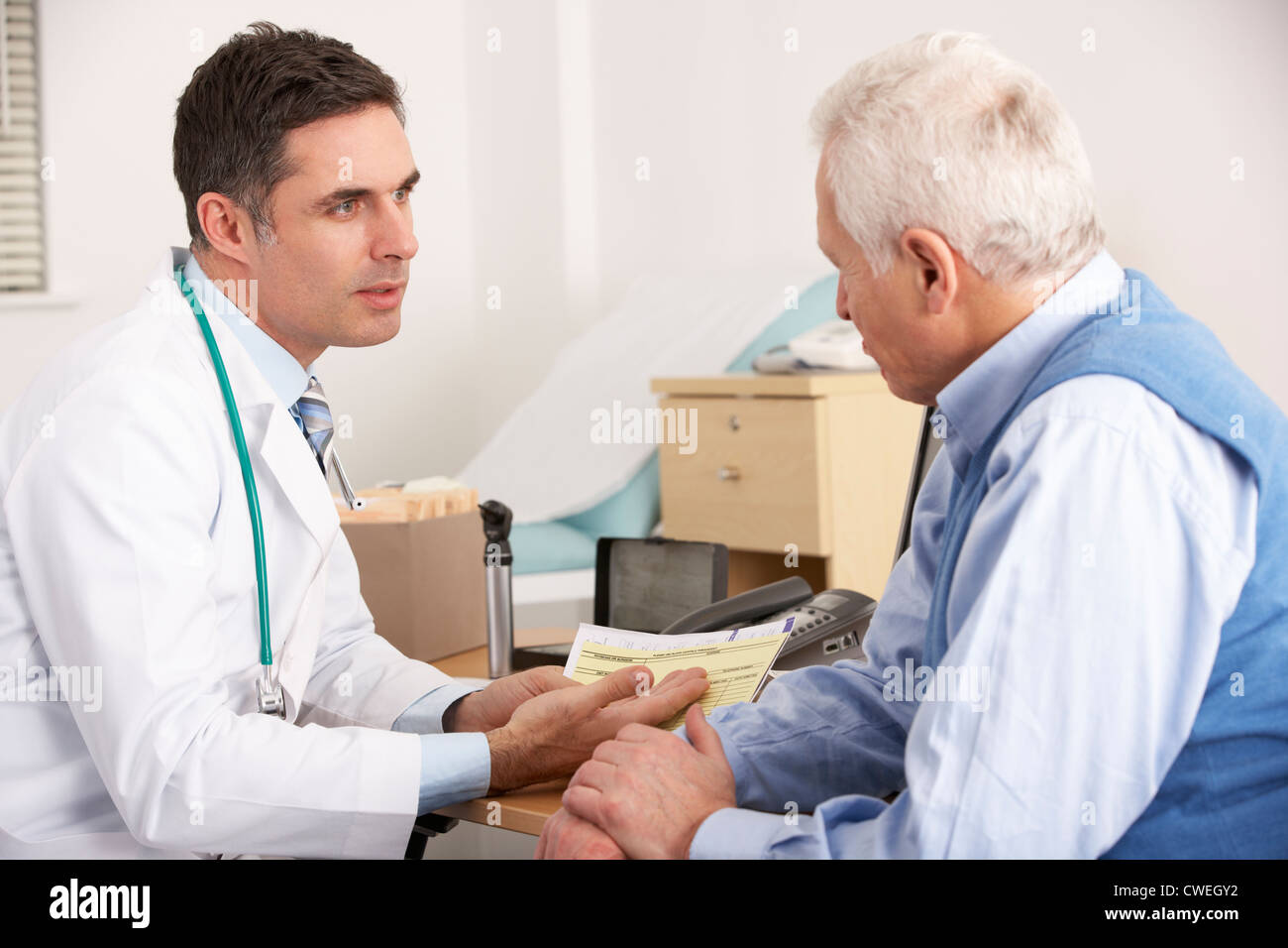 Amerikanischen Arzt im Gespräch mit älteren Mann in der Chirurgie Stockfoto