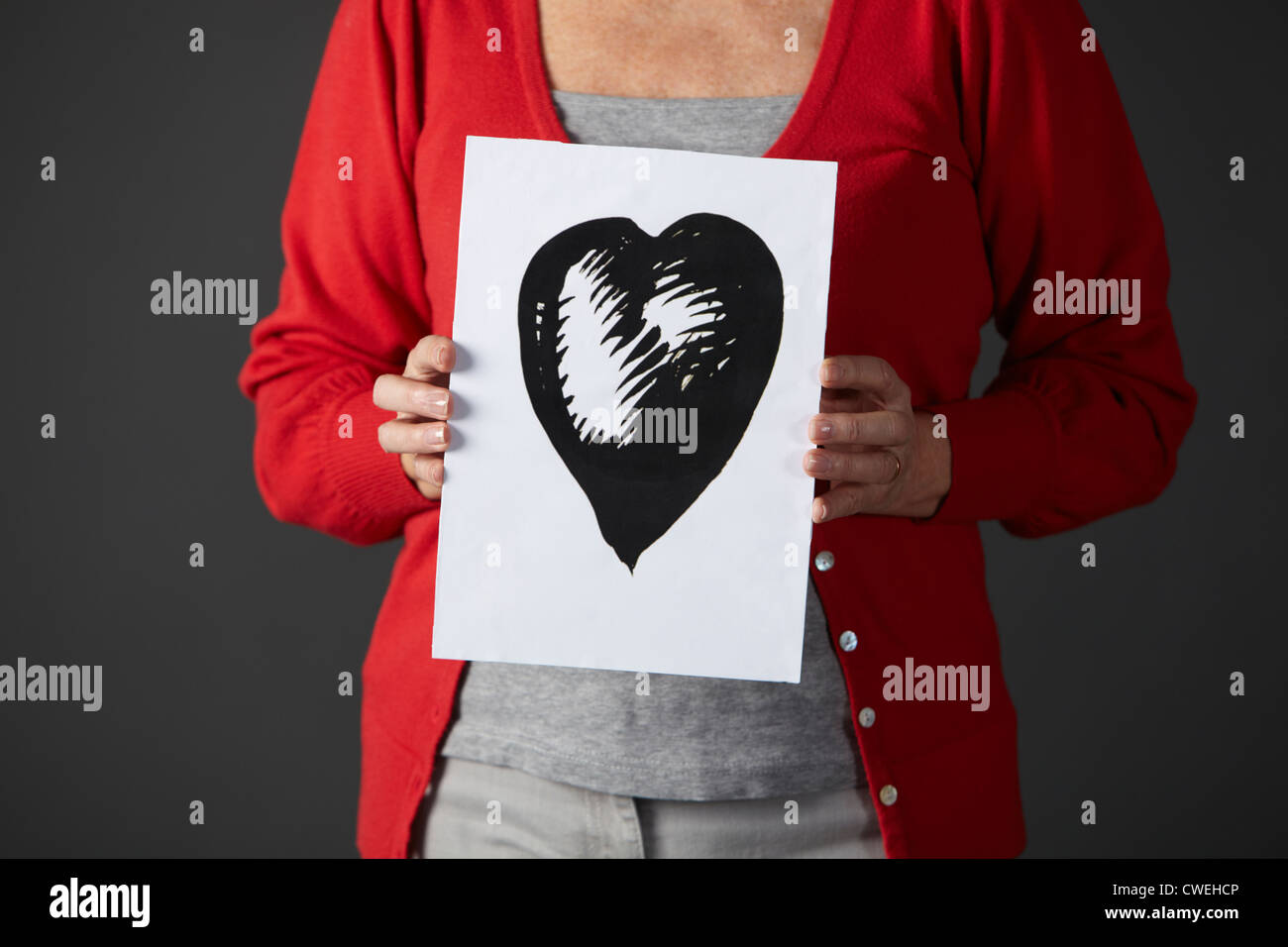 Ältere Frau mit Tusche-Zeichnung des Herzens Stockfoto