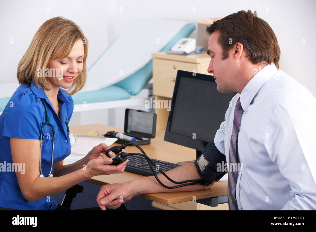 UK-Arzt die Patientin Blutdruckmessung Stockfoto