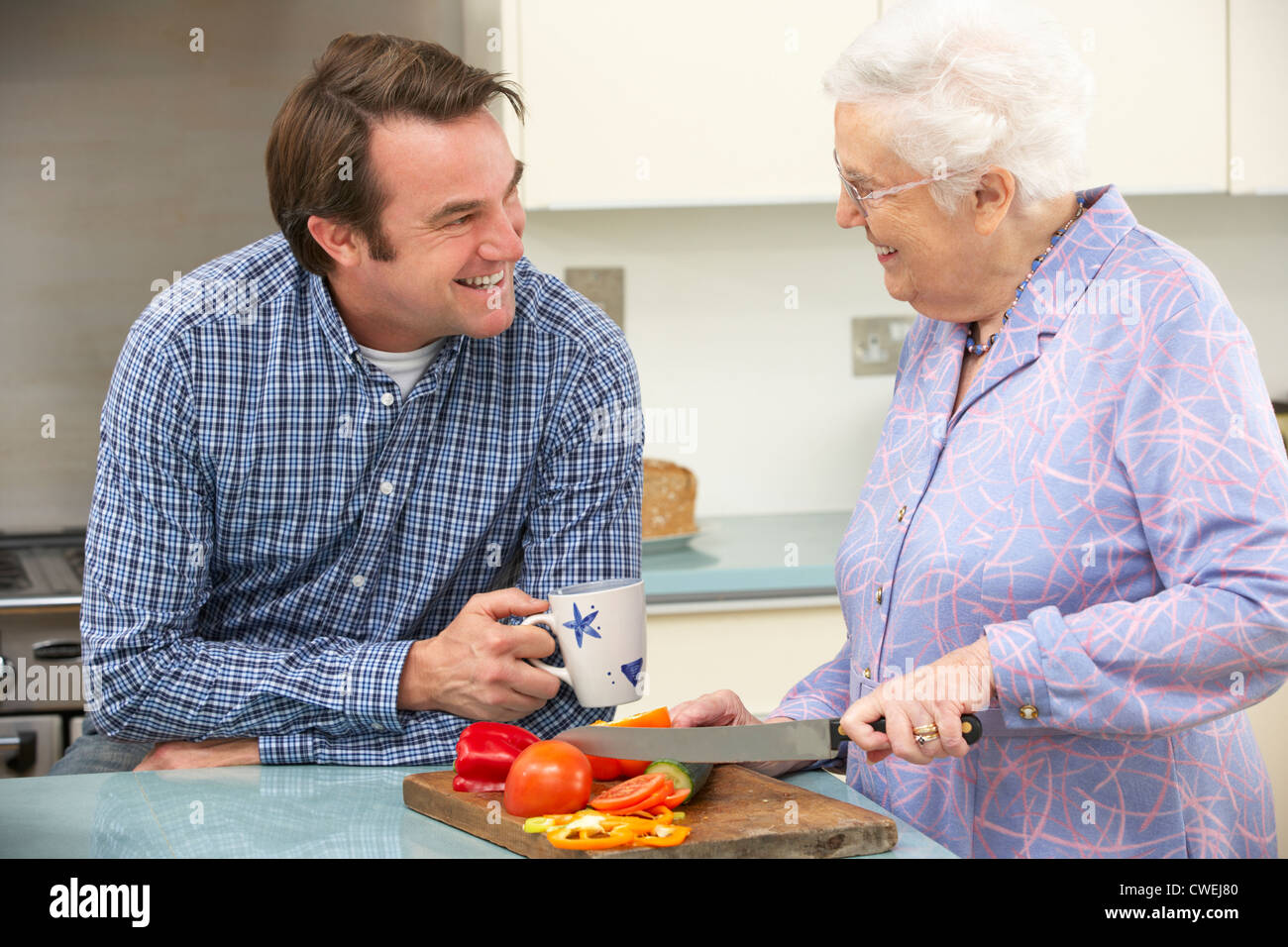 Mutter und erwachsener Sohn Zubereitung zusammen Stockfoto
