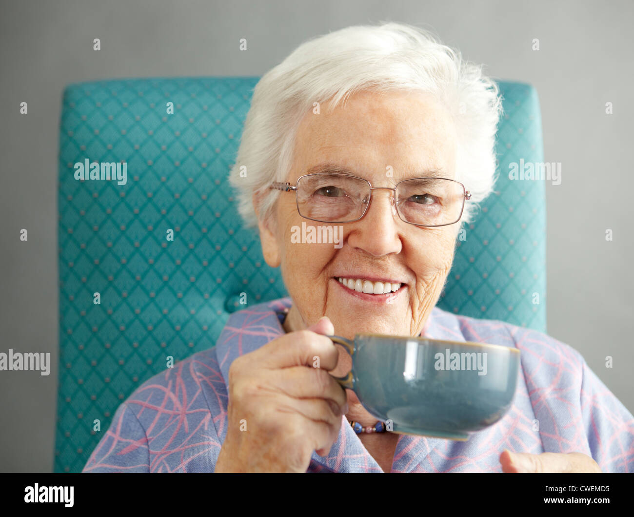 Entspannung In Stuhl mit Heißgetränk Senior Woman Stockfoto