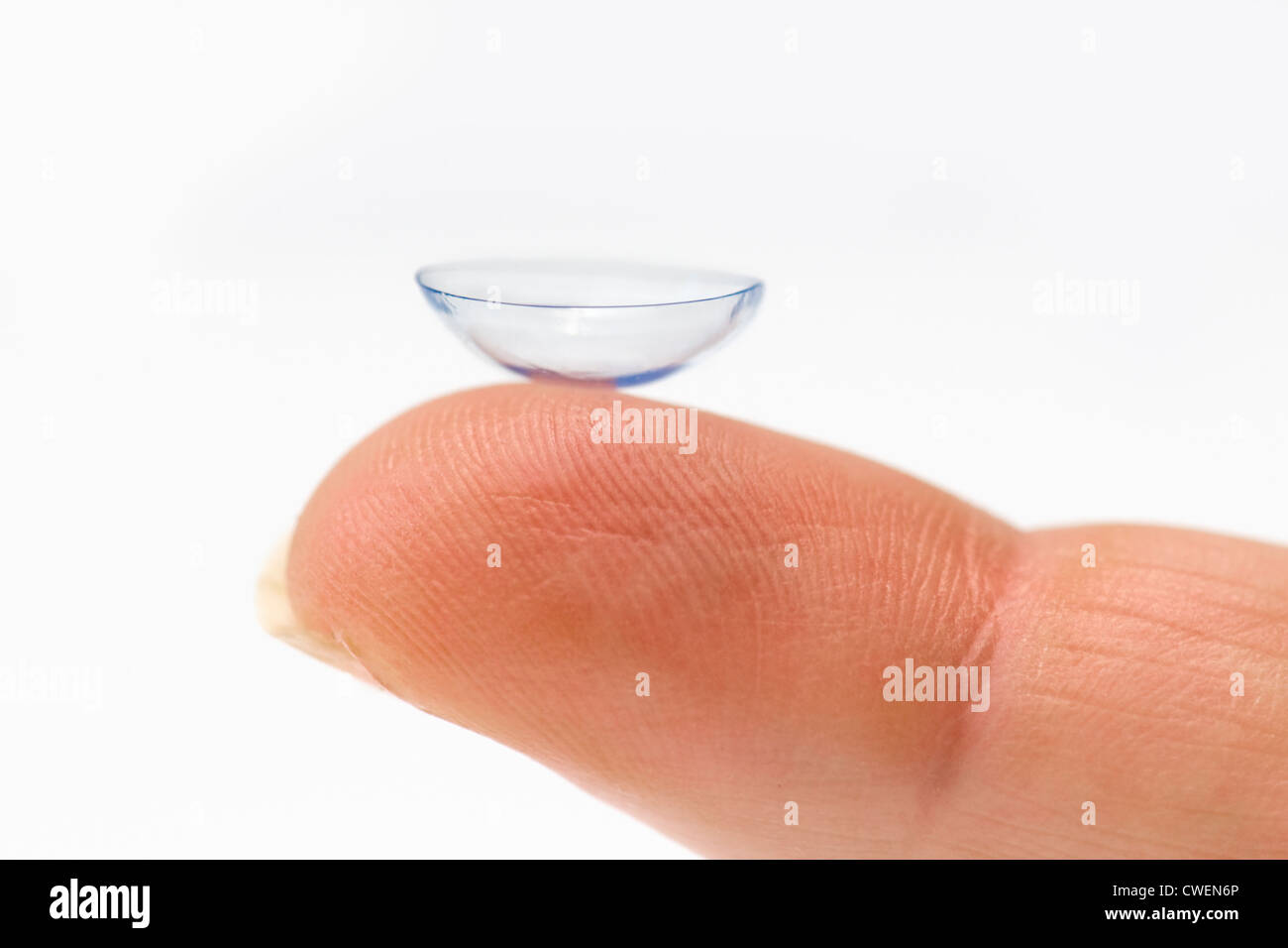 Nahaufnahme eines einzigen Kontaktlinse auf kaukasischen Womans Finger vor weißem Hintergrund Stockfoto