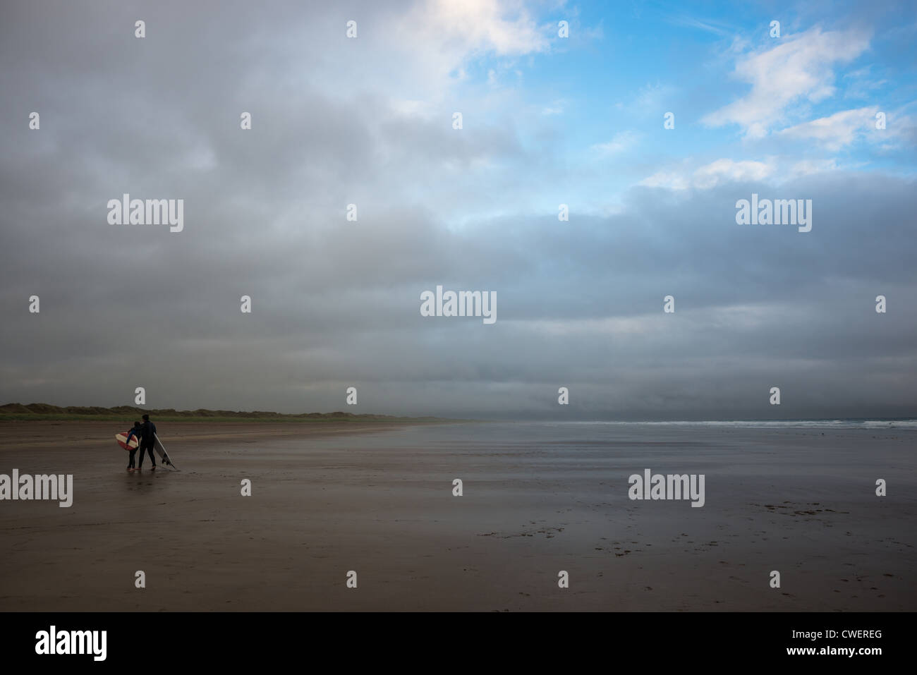 ein paar mit ihren Surfbrettern auf Inch Strand Strand (von Ryans Tochter Fame), Halbinsel Dingle, County Kerry, Irland. Stockfoto